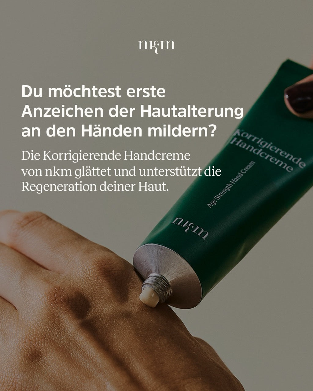 Werbung für die Korrigierende Handcreme von nkm mit Nahaufnahme, wie sie aus einer Tube gedrückt und auf die Hand aufgetragen wird