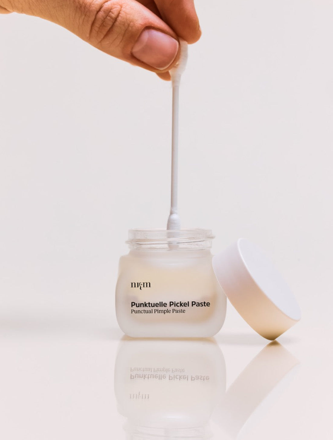 Punktuelle Pickel Paste von nkm wird mit einem Wattestäbchen aufgetragen
