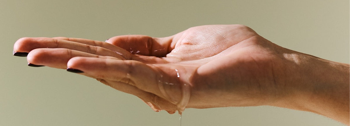 Hand hält Flüssigkeit