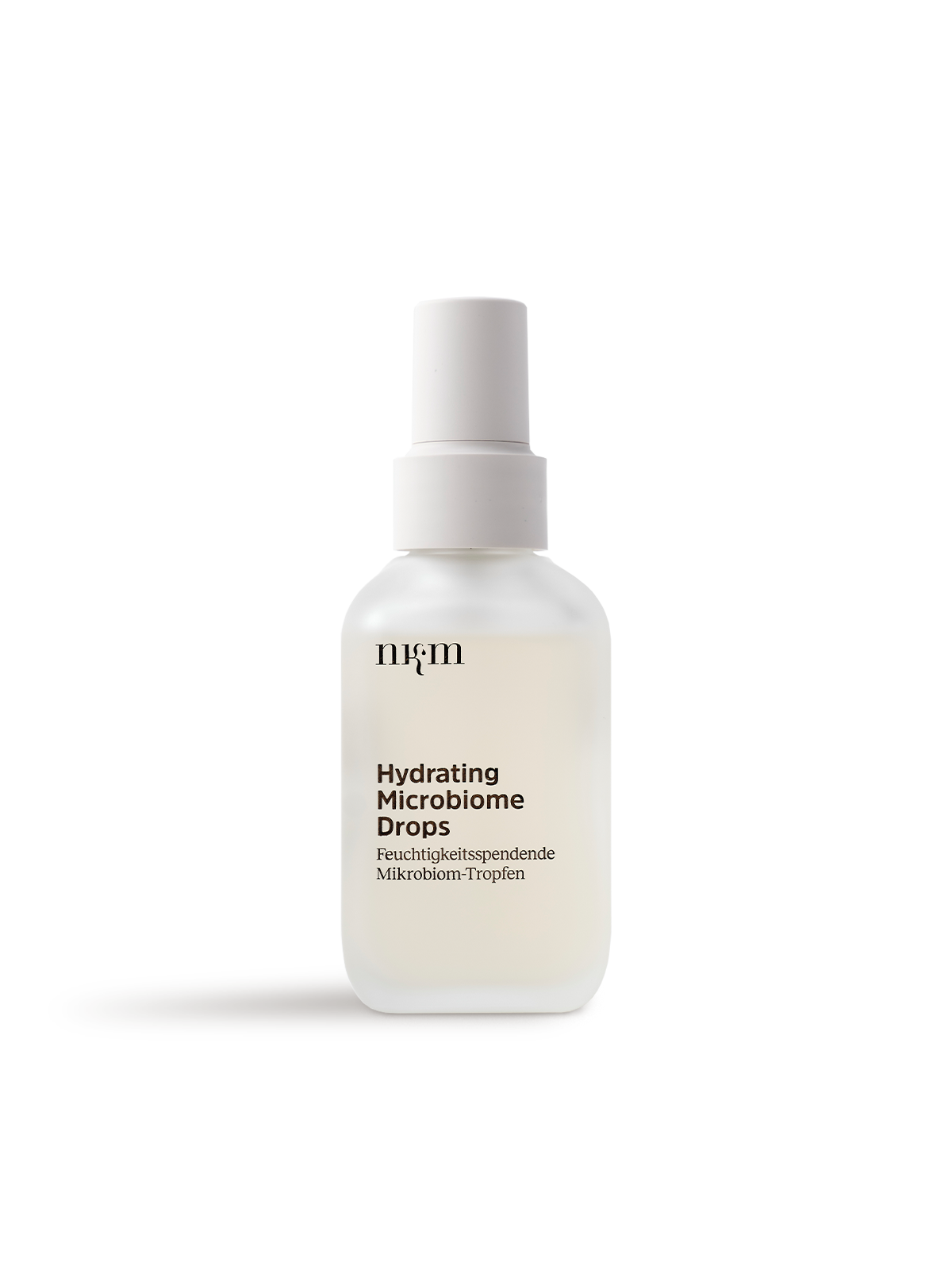 Auf weißem Hintergrund ruht eine mattierte Tropfflasche mit der Aufschrift Hydrating Microbiome Drops von nkm Naturkosmetik München GmbH, ideal für feuchtigkeitsspendendes Liquid und sichtbar hydratisierte Haut.
