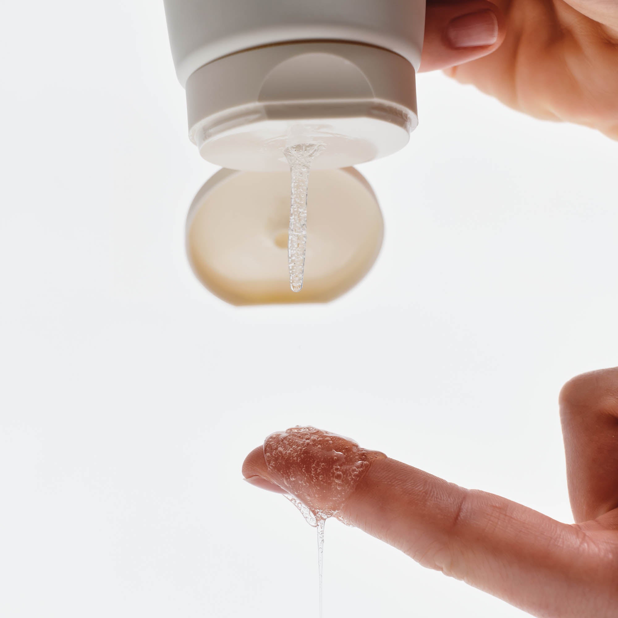 Aus einer Tube wird Gel herausgedrückt und von einem Finger aufgefangen