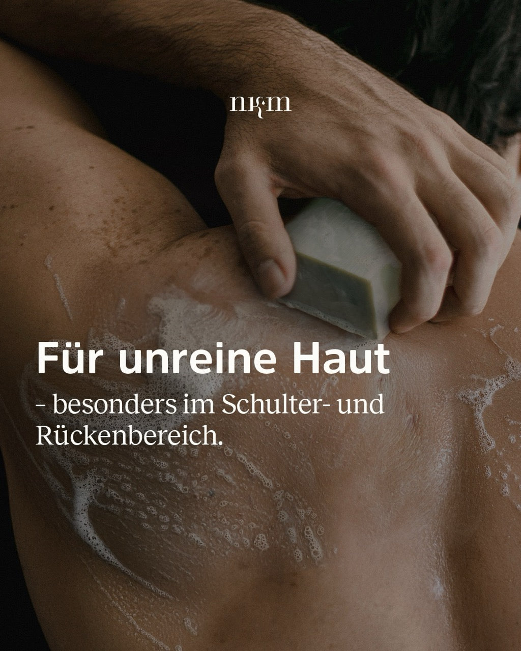 Ein Mann schäumt sich den Rücken mit den Hautklärenden Reinigungsblock ein