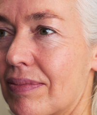 Frau mit grauen Haaren und reifer Haut