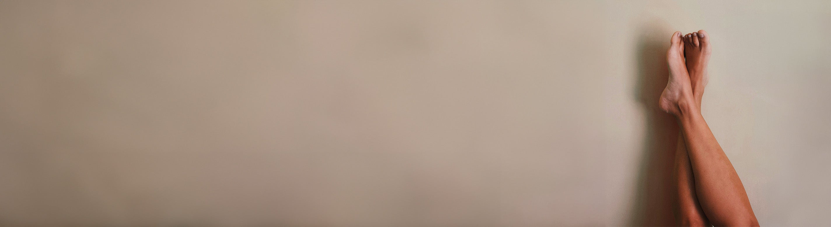 Beine die überschlagen sind und an der Wand lehnen 