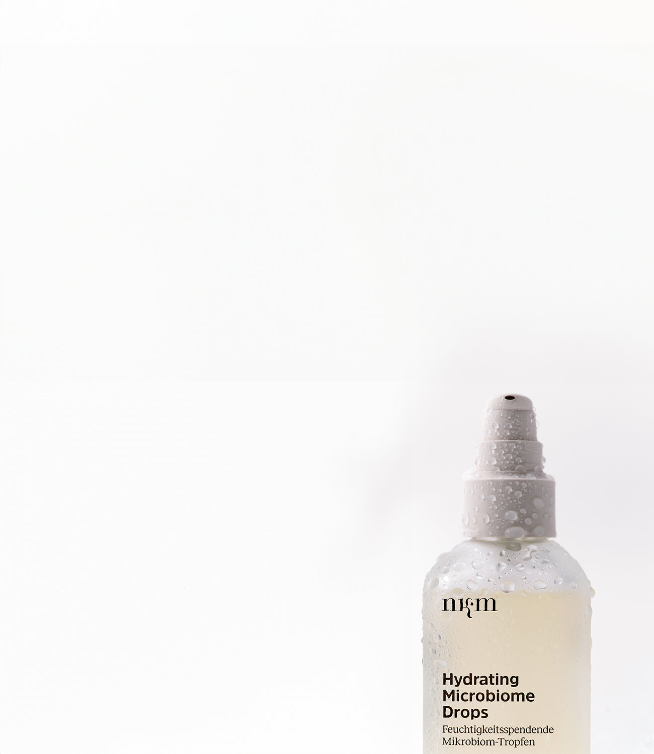 Hydrating Microbiome Drops mit Wassertropfen auf dem Produkt.