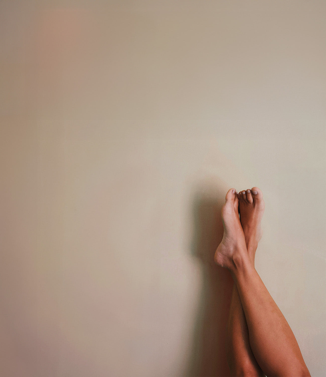 Beine die überschlagen sind und an der Wand lehnen 
