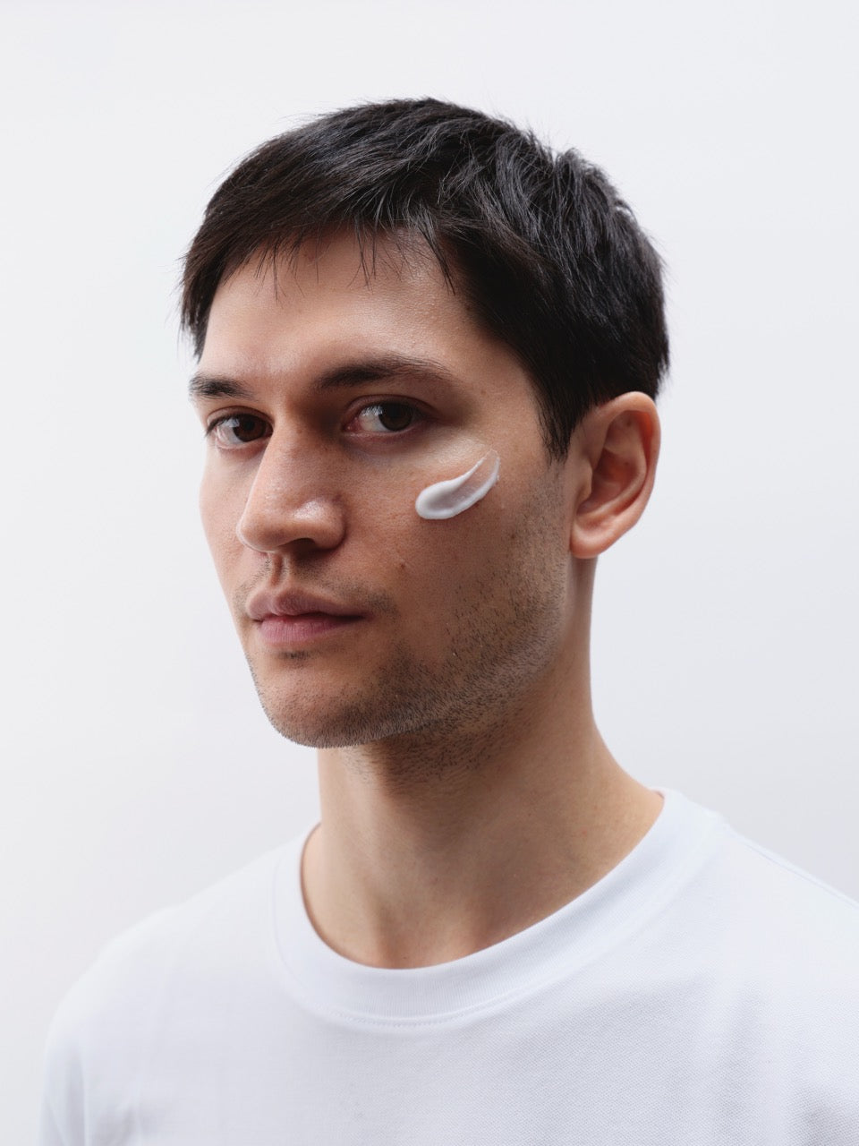 Mann mit dunklen Haaren und Creme im Gesicht